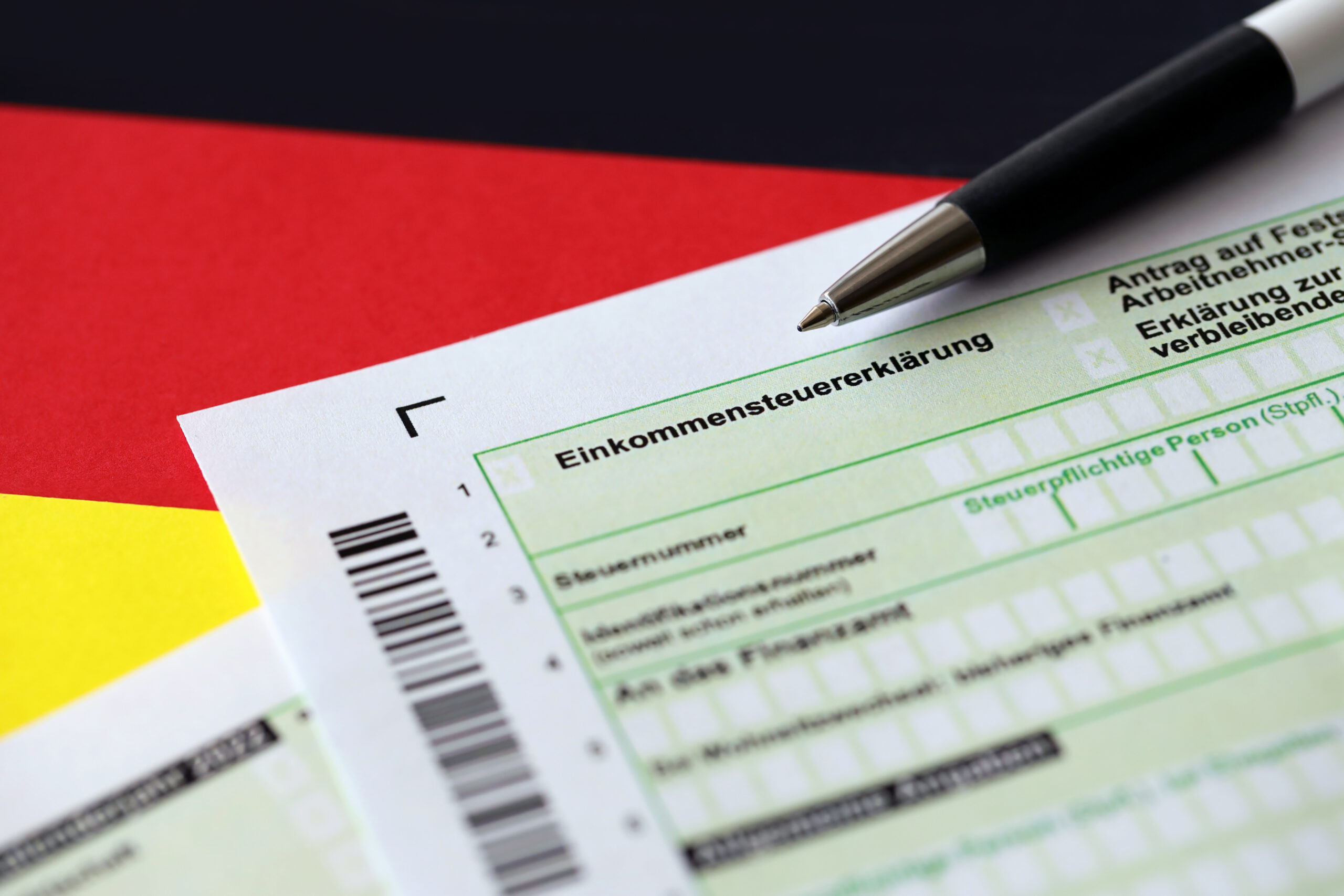 German annual income tax return declaration form with pen on flag close up. The concept of tax reporting in Germany corporate tax germany