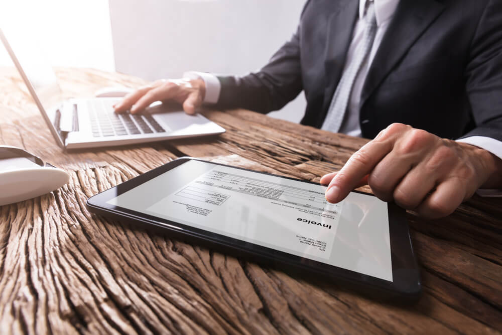 Close-up-Of-A-Businessmans-Hand-Working-With-Invoice-On-Digital-Tablet